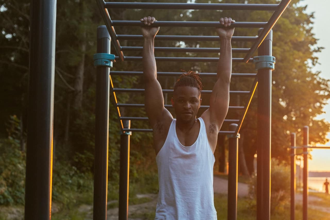 Persona entrenando en barras al aire libre