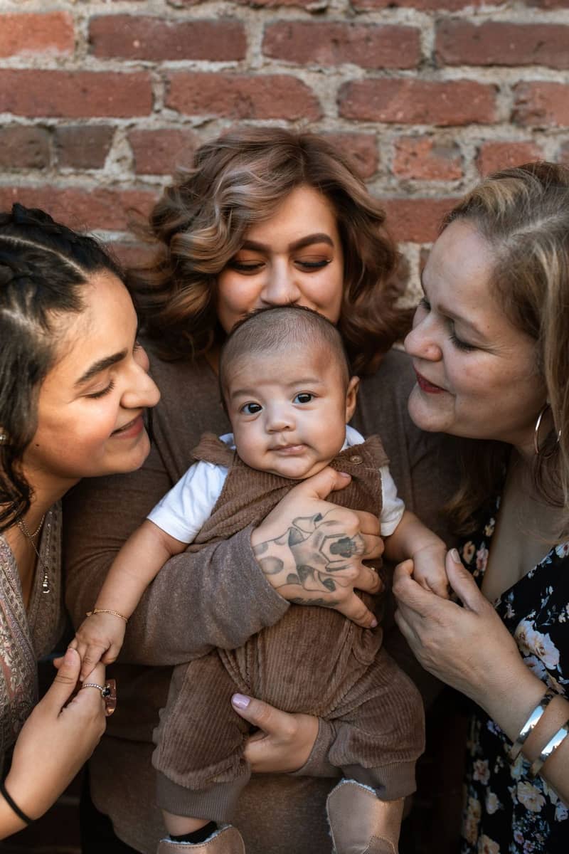Tres generaciones de una familia abrazando a un bebé
