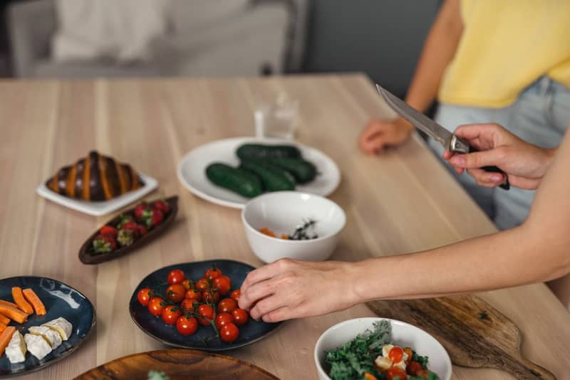 Manos preparando una comida saludable con vegetales frescos