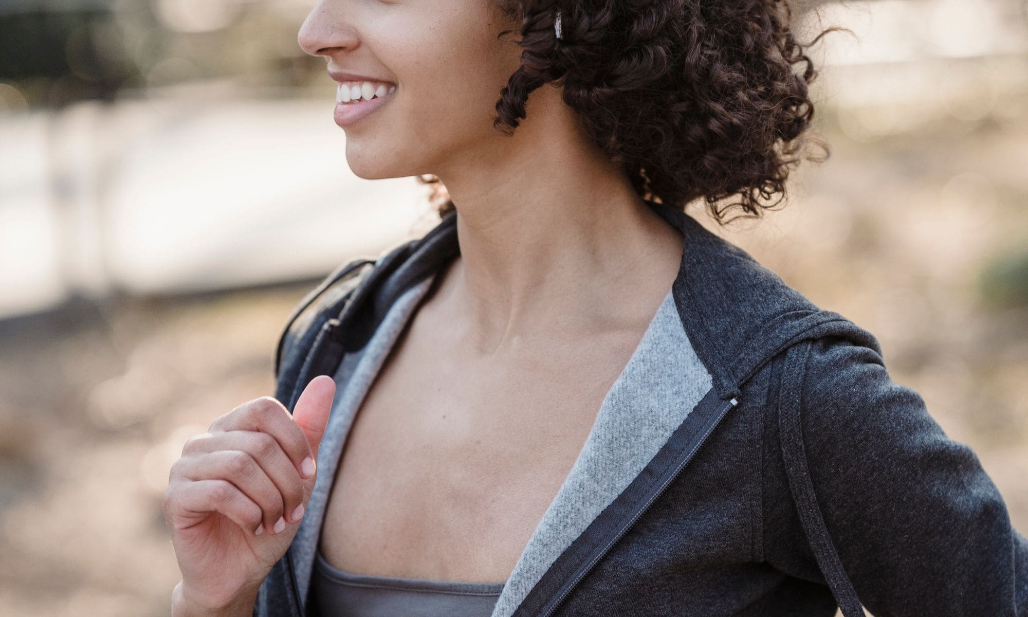 Mujer joven sonriente trotando al aire libre