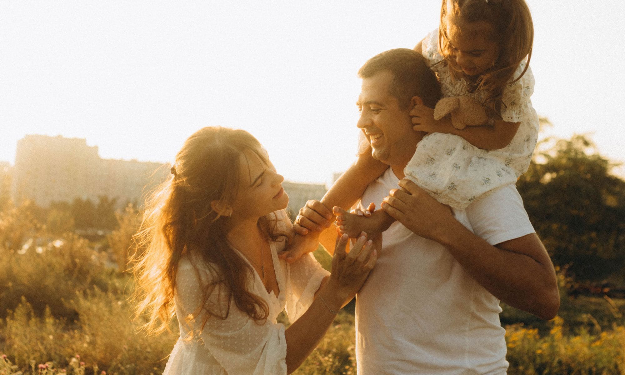 Familia feliz al aire libre a la luz del atardecer